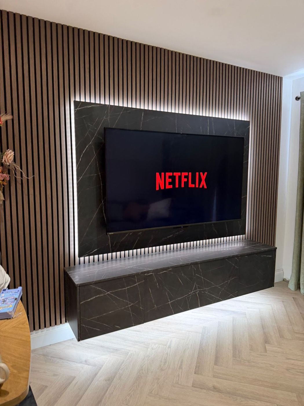 Walnut slat media wall with black floating cabinet